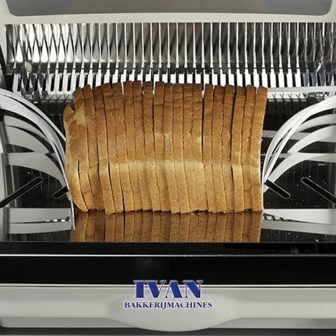Broodsnijmachine Jac SELF PLUS in werking, met nadruk op een brood tussen de messenn