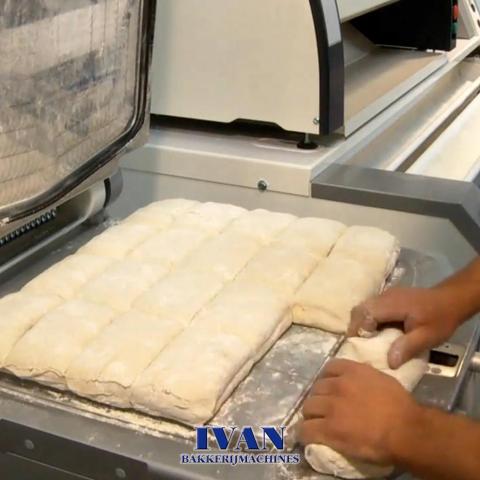 De bakker neemt de eerst deegstukken uit de deegverdeler Jac DIV